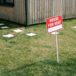 Red and White House for rent sign board on the Lawn Grass